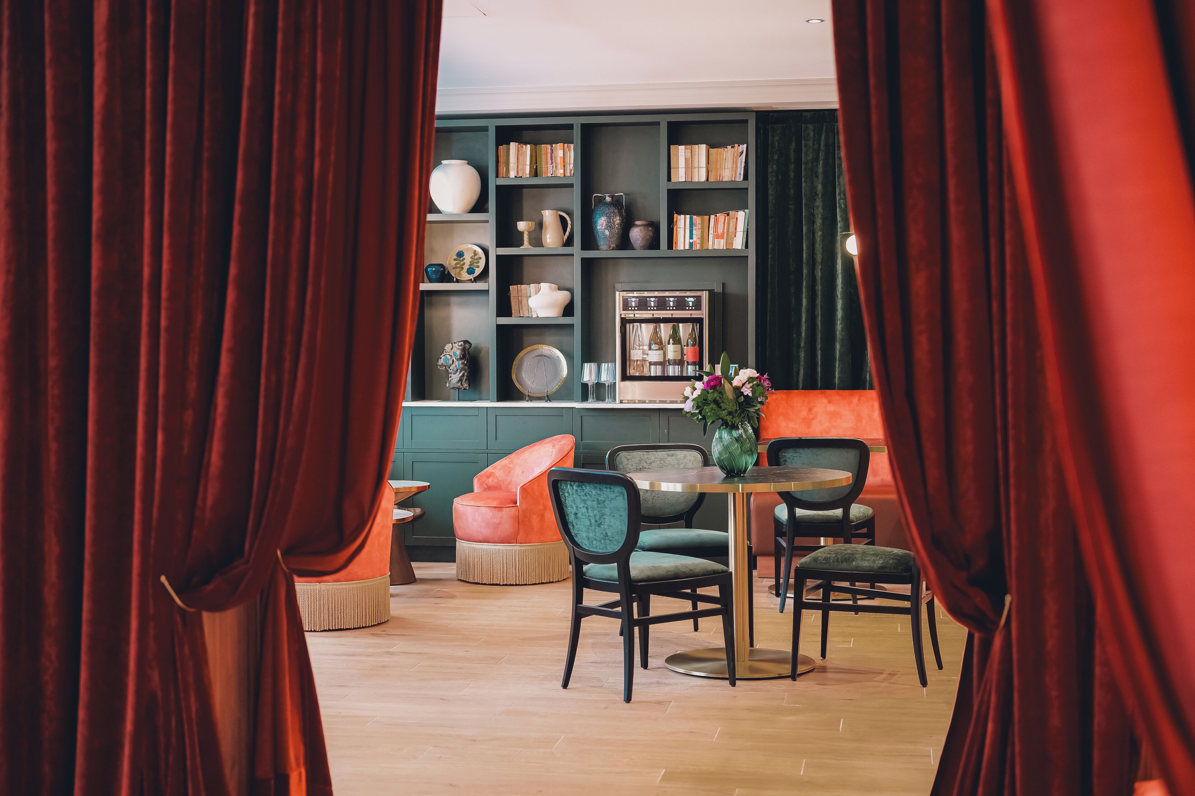A dining area with a table, chairs, and a bookshelf filled with books and decorative items.