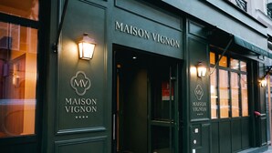 Fachada de un edificio con el rótulo 'MAISON VIGNON', un logotipo y la entrada principal.