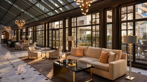 A spacious lobby with a high ceiling, large windows, and a modern chandelier. - Fairmont Washington, D.C., Georgetown (Washington)