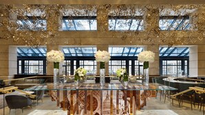A modern hotel lobby with a glass-top reception desk, marble flooring, and large windows offering city views. - Fairmont Washington, D.C., Georgetown (Washington)