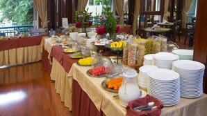 A buffet setup with various food items and dishes. - Apartotel & Suites Villas del Rio (San Rafael)