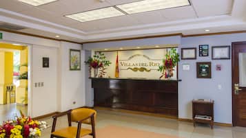 A reception area with a reception desk, a chair, and a small table with magazines.