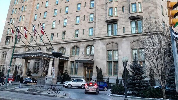 A large, historic building with multiple floors, a prominent entrance, and flags on the roof. - The Fort Garry Hotel, Spa and Conference Centre, an Ascend Collection Hotel (Winnipeg)