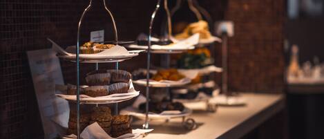 A buffet setup with multiple serving trays and a menu sign.