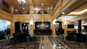 A grand lobby with a marble floor, ornate chandeliers, and a central black reception desk. - The Fort Garry Hotel, Spa and Conference Centre, an Ascend Collection Hotel (Winnipeg)