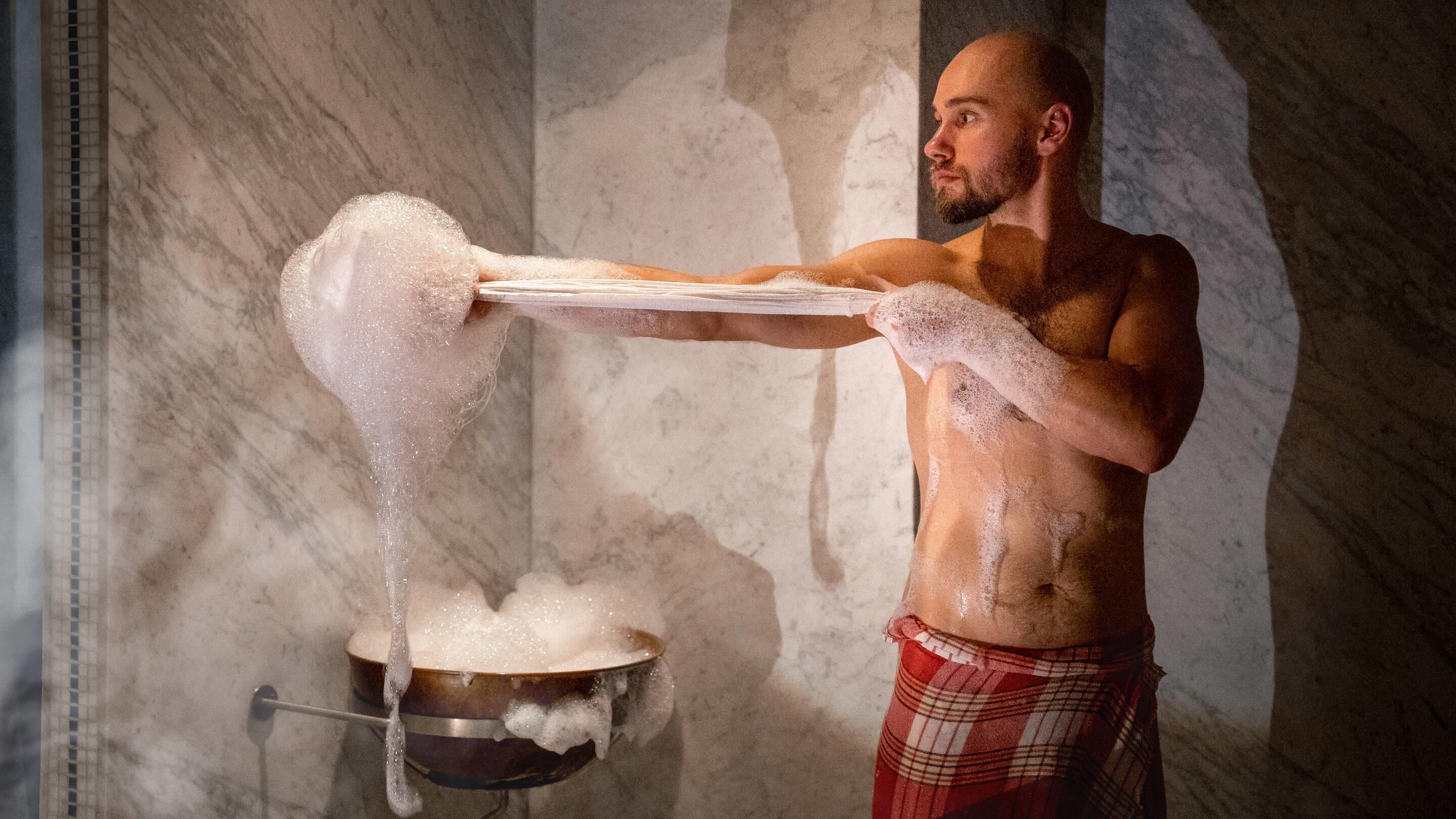 A person pouring a liquid from a tray into a pot.
