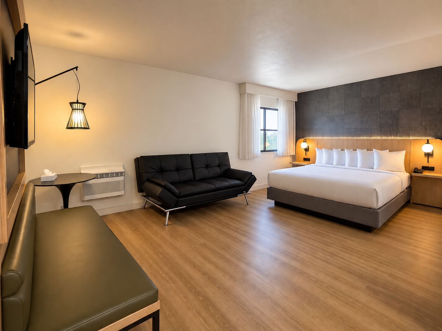 Una habitación de hotel moderna con cama, sofá, escritorio y televisión.