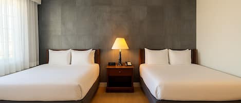 Habitación Deluxe, 2 camas matrimoniales | Escritorio, cortinas blackout y tabla de planchar con plancha