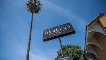 A hotel sign with 'GRANADA Santa Clara Hotel' and a smaller sign below stating 'YOUR HOME AWAY FROM HOME.'