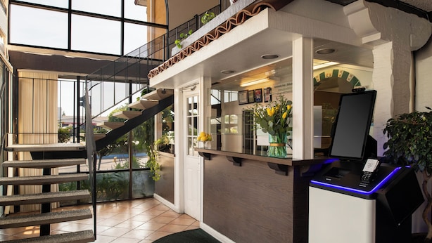 A reception desk with a NexTap logo, a staircase, and a view of the outside.