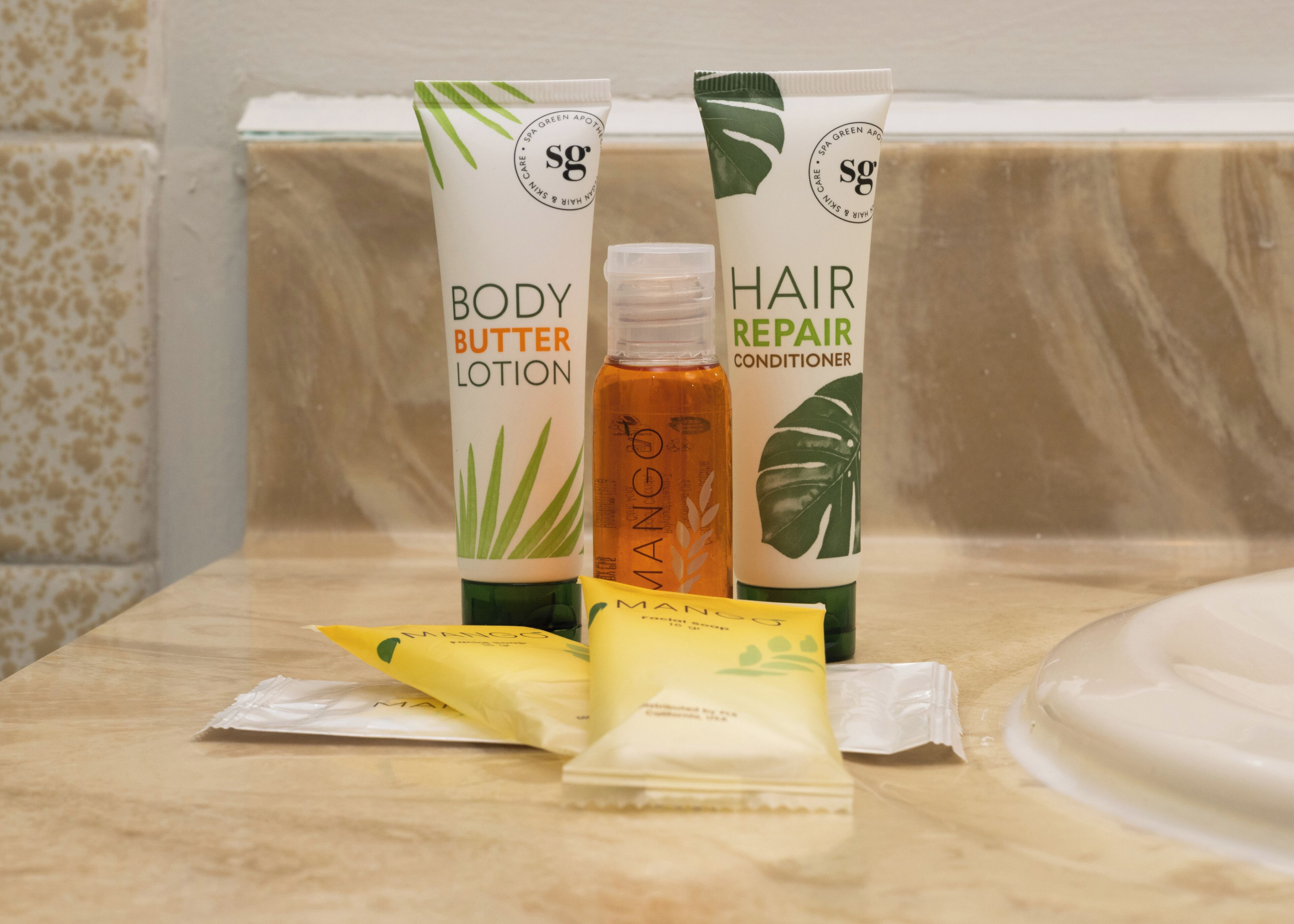 Een badkamermeubel met bodylotion, haarmasker en mangoshampoo.