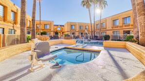 A pool area with a hot tub, palm trees, and a building with multiple windows. - Best Western Green Valley Inn (Green Valley)