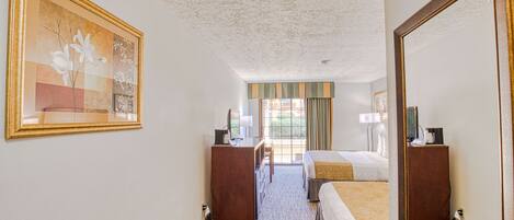 Quarto de hotel com uma cama grande, uma escrivaninha, uma cadeira, um armário e um quadro na parede.