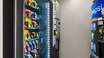 Una máquina expendedora con aperitivos y un dispensador de Pepsi.