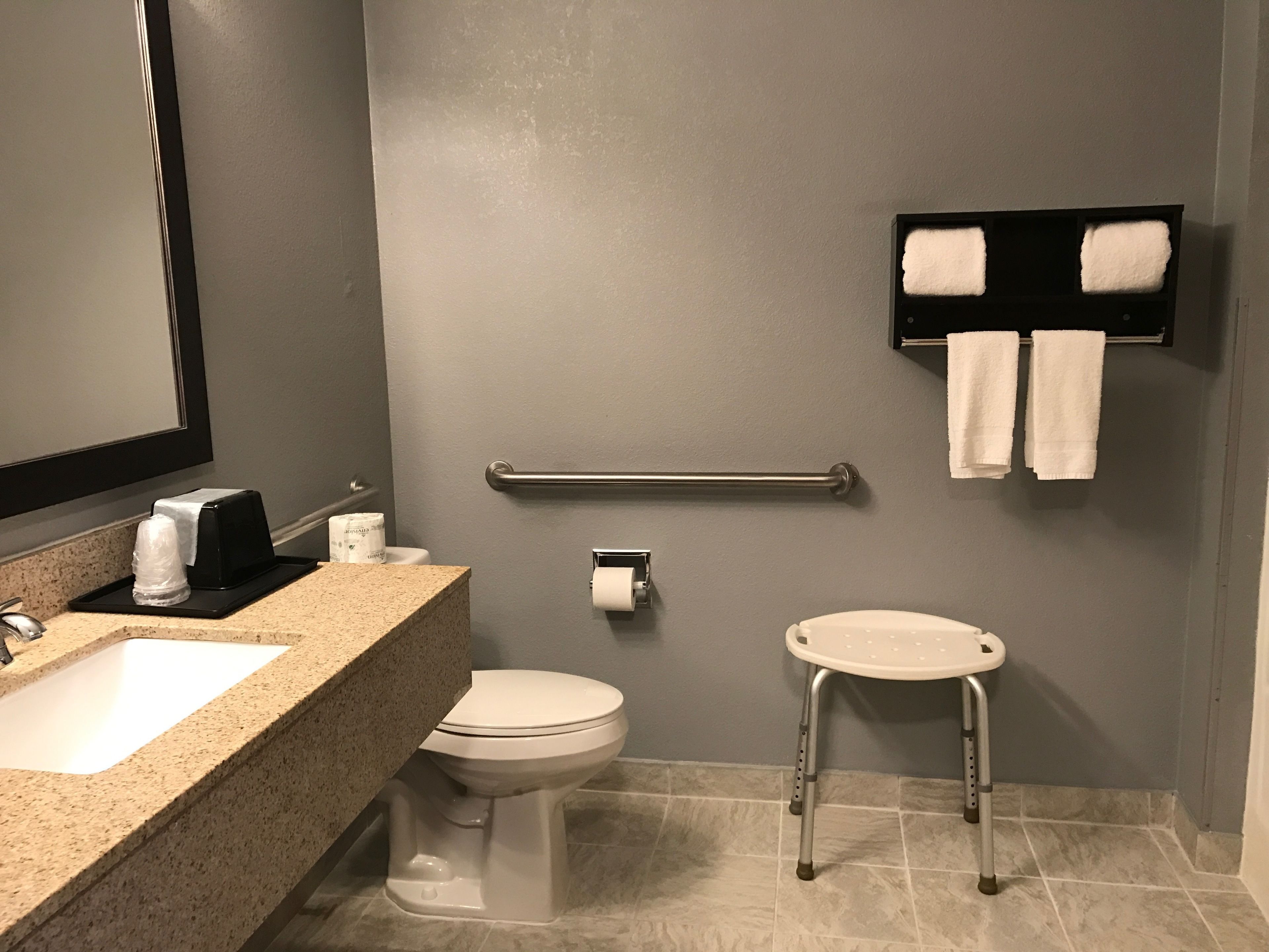 Ein Badezimmer mit Waschbecken, Toilette und einer Haltestange.
