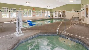 An indoor swimming pool with a water slide, lounge chairs, and a lifeguard station. - Best Western Plus Columbia River Inn (Cascade Locks)