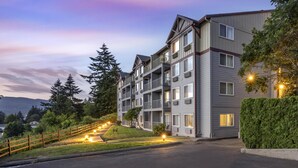 A multi-story residential building with balconies, a well-maintained lawn, and a view of distant mountains. - Best Western Plus Columbia River Inn (Cascade Locks)