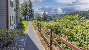A pathway leading to a building with a view of a forest and a bridge. - Best Western Plus Columbia River Inn (Cascade Locks)