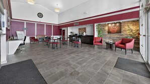 Un hall d’entrée spacieux avec un comptoir d’accueil, un espace salon et une enseigne Red Roof Inn.