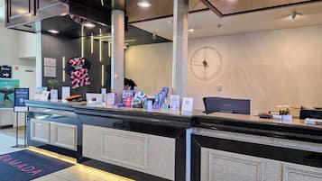 A reception desk with informational brochures, a scale, and a Lenovo computer.