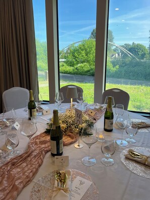 A table set for a meal with wine glasses, bottles, and a menu. - Ramada by Wyndham Tukwila Southcenter (Tukwila)