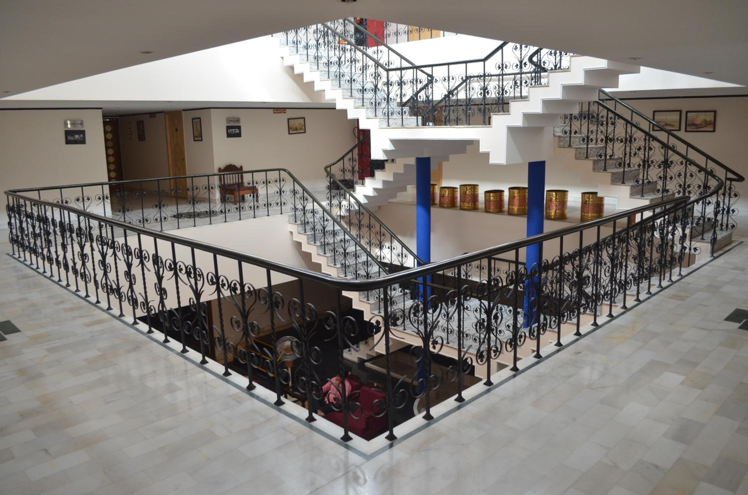 A multi-level interior with a central staircase, railings, and a seating area.