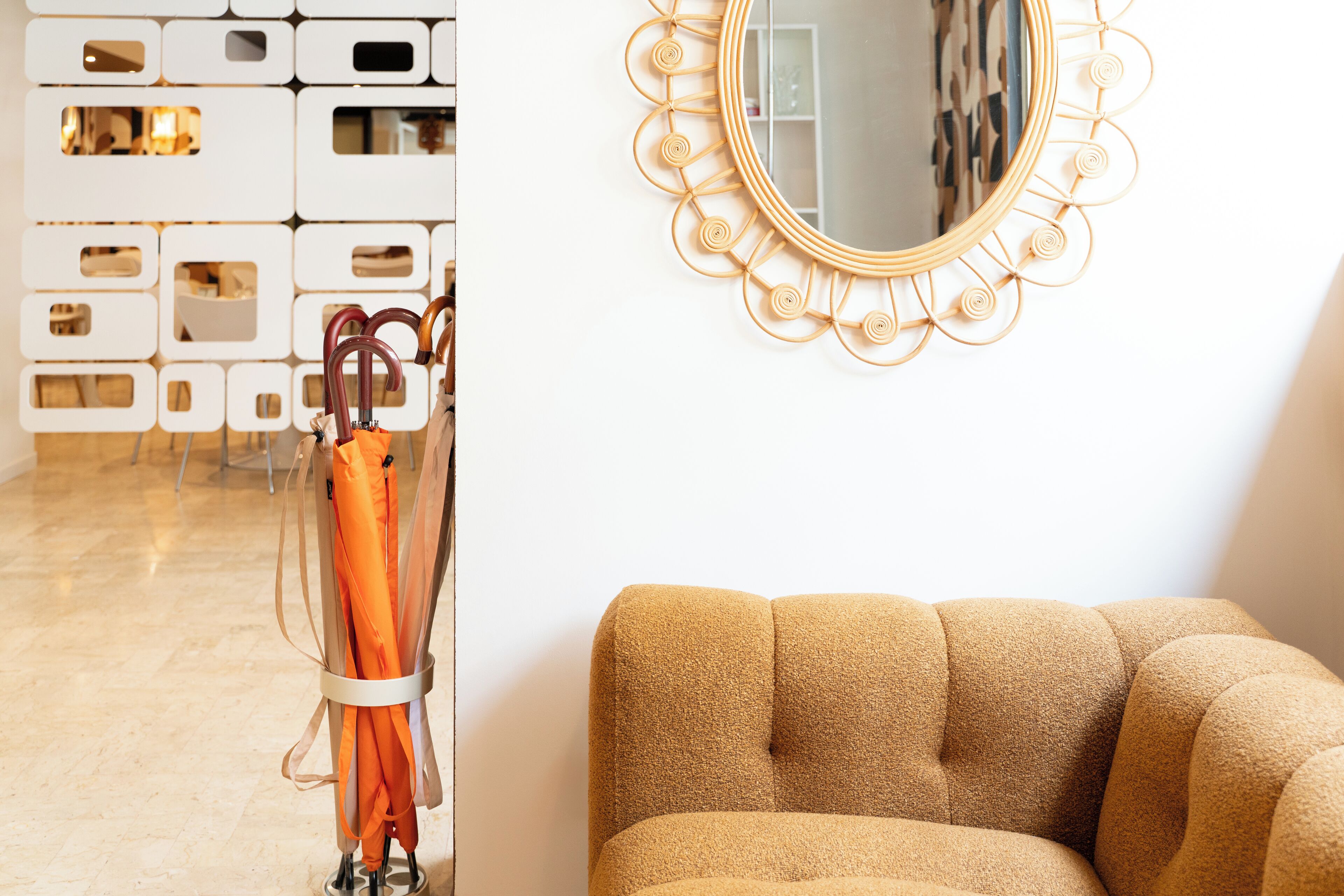 A modern interior with a patterned wall, a round mirror, and a sofa.