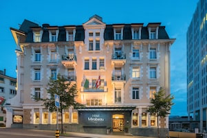 Un hotel de varios pisos con un diseño arquitectónico clásico, con balcones y una entrada destacada.