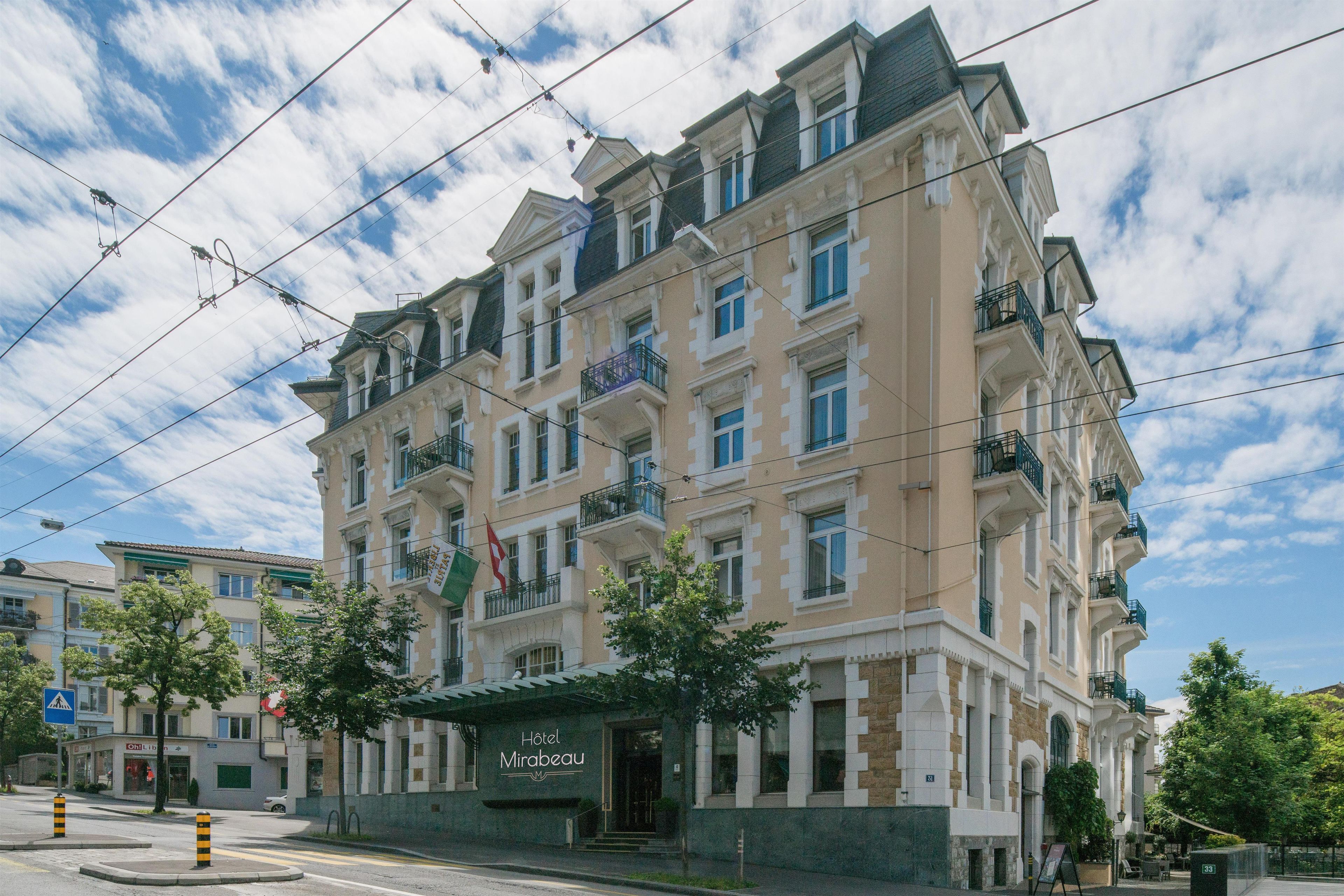 Ein mehrstöckiges Hotel mit klassischer Architektur, mit Balkonen und einem markanten Eingang.