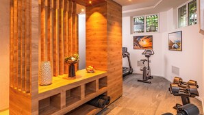 A modern gym with wooden accents, exercise equipment, and artwork on the walls. - Hotel Mirabeau, BW Signature Collection (Lausanne)