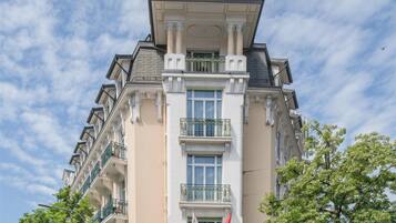 A multi-story hotel with a classic architectural style, featuring a prominent entrance, balconies, and a flag.