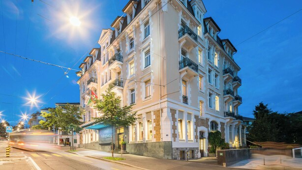 A multi-story hotel with balconies, a well-lit facade, and a clear view of the street. - Hotel Mirabeau, BW Signature Collection (Lausanne)