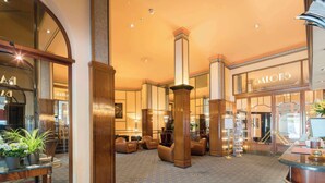A spacious lobby with a patterned carpet, wooden columns, and comfortable seating areas. - Hotel Mirabeau, BW Signature Collection (Lausanne)