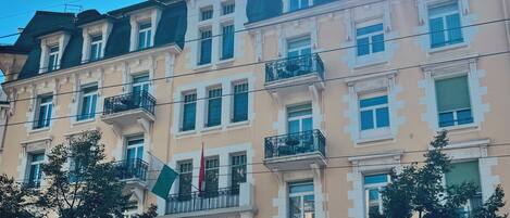 A multi-story hotel with a classic architectural style, featuring balconies and a prominent entrance.