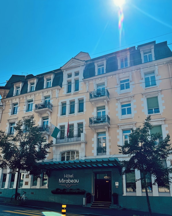 Un hotel de varios pisos con un estilo arquitectónico clásico, que cuenta con balcones y una entrada destacada.
