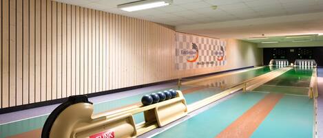 Eine Kegelbahn mit Holzwand, einer Bowlingbahn und einem Rücklaufwaggon.