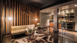 A modern living room with a leather sofa, a wooden slat wall, and a glass cabinet with decorative items.