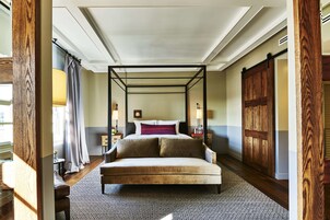 Una cama con dosel en una habitación de hotel con vistas a la ciudad.
