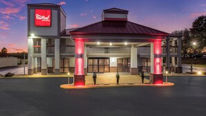 A Red Roof Inn & Suites with a covered entrance, multiple floors, and a brick facade. - Red Roof Inn & Suites Athens, AL (Athens)