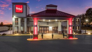 A Red Roof Inn with a modern design, featuring a prominent red roof and illuminated signage. - Red Roof Inn & Suites Athens, AL (Athens)