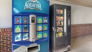 A vending machine with a blue Aquafina logo and a selection of beverages. - Red Roof Inn & Suites Athens, AL (Athens)