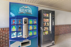 Un distributeur automatique orné du logo bleu d’Aquafina et proposant un assortiment de boissons.