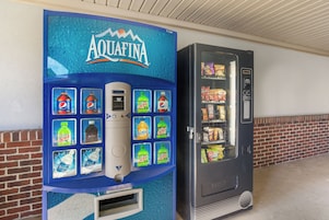 Una máquina expendedora con el logo azul de Aquafina y una variedad de bebidas.