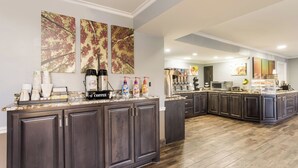 A modern kitchen with a marble countertop, dark wood cabinets, and a coffee station. - Red Roof Inn & Suites Athens, AL (Athens)