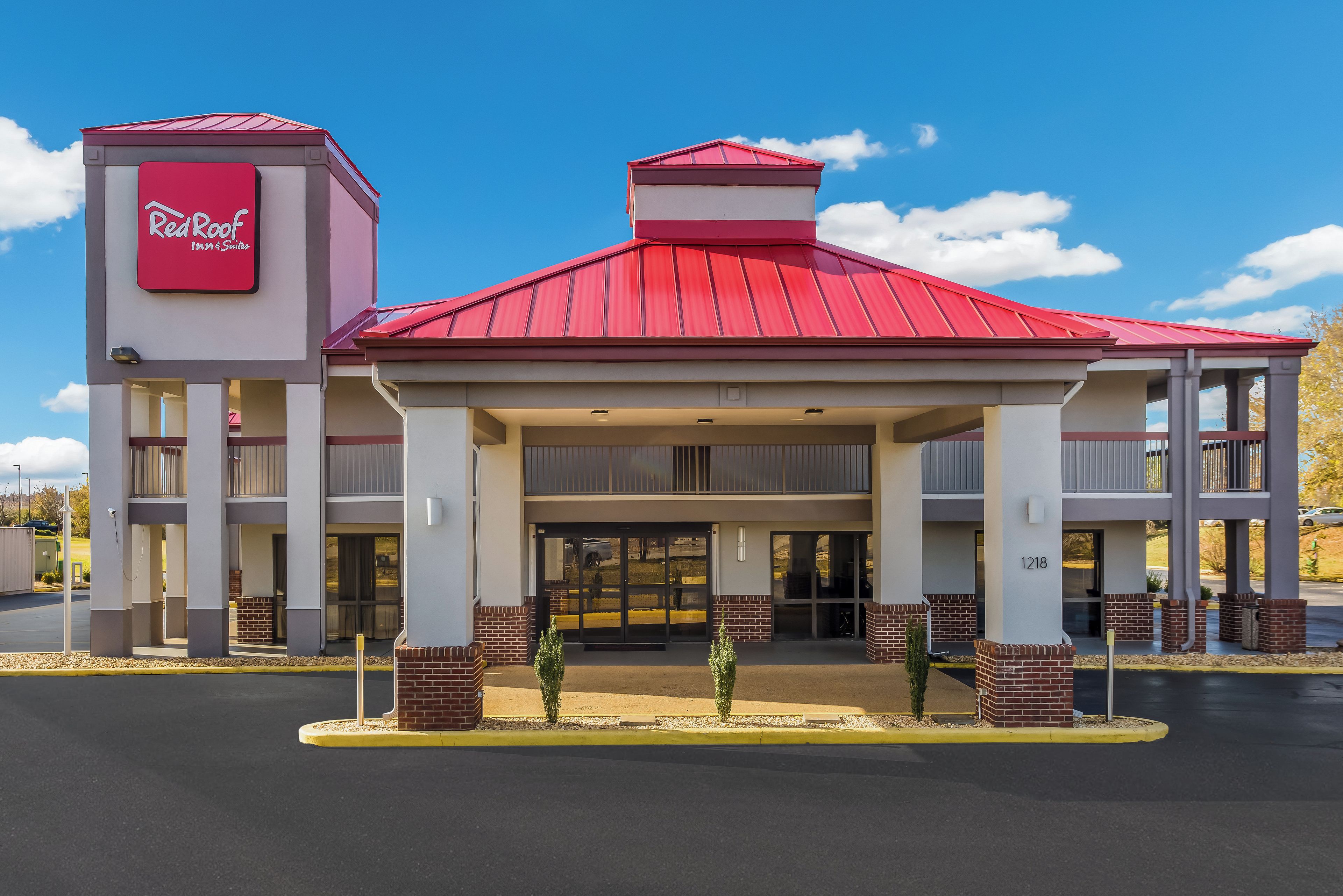 A Red Roof Inn & Suites with a red roof, two-story structure, and a covered entrance.