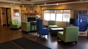 A lobby with a stone wall, green and blue seating, a fireplace, and a large window. - Comfort Inn Salida (Salida)