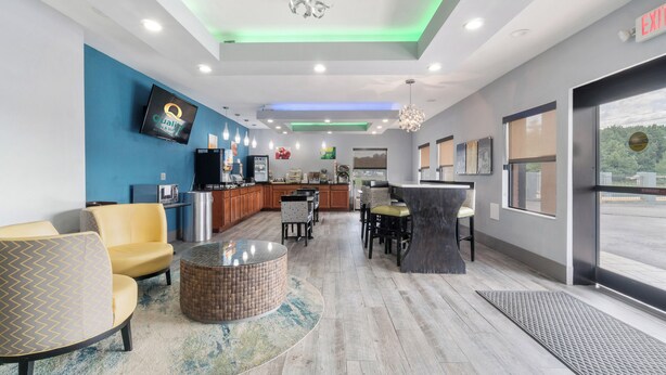 A modern hotel lobby with a bar area, seating, and a television. - Quality Inn Adairsville - Calhoun South (Adairsville)