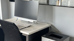 A workspace with a desktop computer, a printer, and documents on the wall. - Quality Inn Adairsville - Calhoun South (Adairsville)