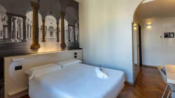 Una habitación de hotel con una cama grande, un escritorio y un mural de un edificio clásico.