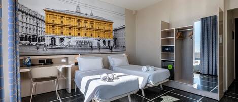 Una habitación de hotel con cama, escritorio, silla, armario y un ventanal grande.